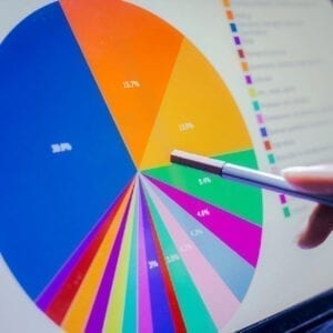 A person is pointing to a pie chart on the screen.