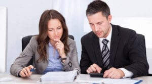 A man and woman are working on paperwork.
