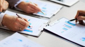 A person is writing on some papers