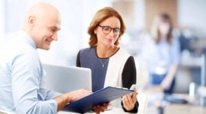 A man and woman looking at a laptop.