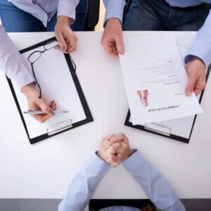 A group of people sitting at a table with papers.