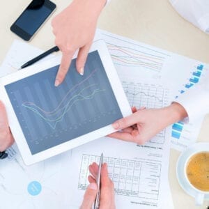 A person holding an ipad with a chart on it